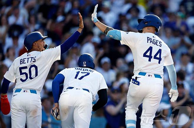 LA 다저스 앤디 파헤스(오른쪽)가 16일(한국시간) 열린 2025 메이저리그 샌프란시스코 자이언츠전에서 5회말 역전 결승 3점 홈런을 터뜨린 뒤 무키 베츠(왼쪽)의 축하를 받고 있다. ⓒ AFP=뉴스1