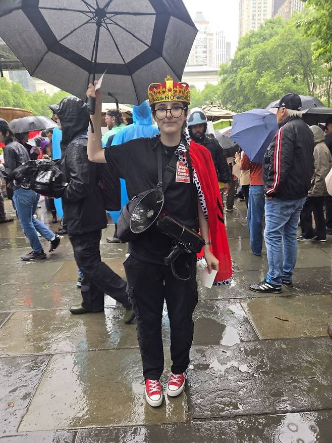 14일(현지시간) 미국 뉴욕 맨해튼 브라이언트 파크에서 열린 '노 킹스' 집회에서 한 참가자가 사진 촬영을 하고 있다. 뉴욕=권해영 특파원