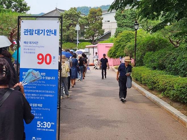 지난 13일 시민들이 청와대 본관 관람을 위해 길게 줄을 선 가운데 안내판에는 예상 대기시간이 90분이라고 표시돼 있다. 변선진 기자