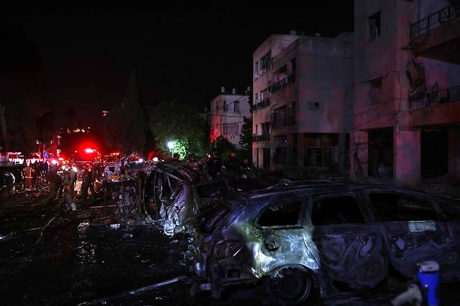 15일(현지 시각) 이란의 로켓 공격을 받은 이스라엘 하이파시 현장에 이스라엘 긴급 및 보안 요원이 배치된 모습. /AFP=연합뉴스
