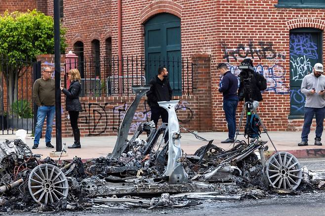 9일 미국 로스앤젤레스 시내에 시위대가 불 태운 웨이모 차량. /연합뉴스