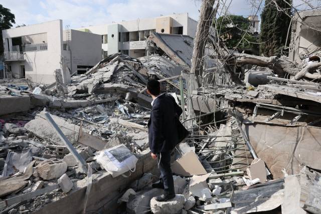 16일(현지시간) 이스라엘 미사일 공격으로 파괴된 건물 폐허를 시민이 바라보고 있다. EPA 연합뉴스