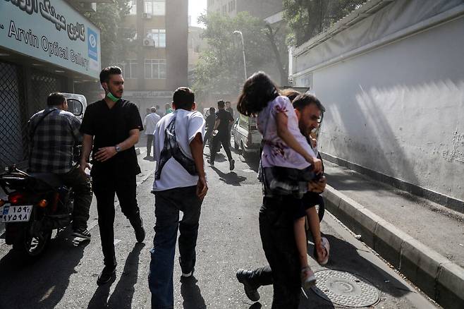 15일 이스라엘군의 공습 뒤 이란 수도 테헤란에서 거리로 나온 시민들이 뛰고 있다. WANA 연합뉴스