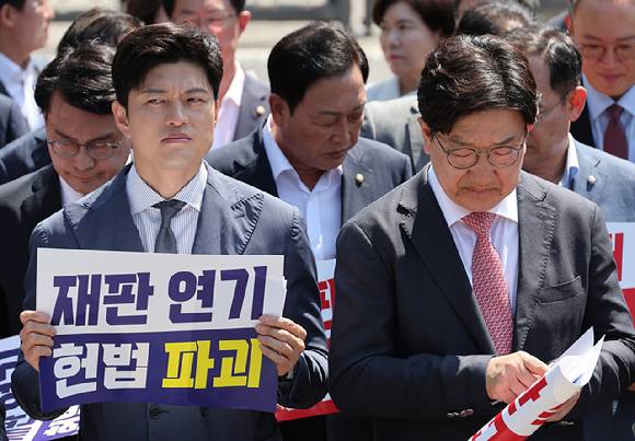 국민의힘 김용태 비상대책위원장과 권성동 원내대표가 11일 이재명 대통령의 공직선거법 위반 사건의 파기환송심을 사실상 무기한 연기한 서울고등법원 앞에서 열린 현장 의원총회를 마무리 하고 있다. [사진=연합뉴스]