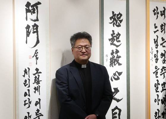 ‘축성의 서예가 심성필성 작품 총서 출판기념전’ 전시회에 참여한 정성훈 신부. [뉴시스]