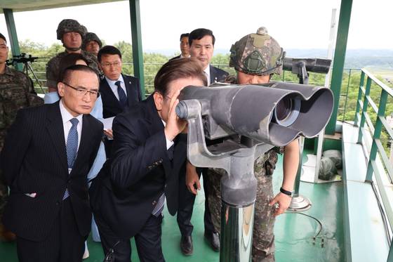 이재명 대통령이 지난 13일 경기 연천군 25사단 비룡 전망대를 방문해 망원경으로 북한 지역을 살펴보고 있다. 이 대통령은 대북 확성기 방송의 중단을 직접 지시했다. [대통령실사진기자단]