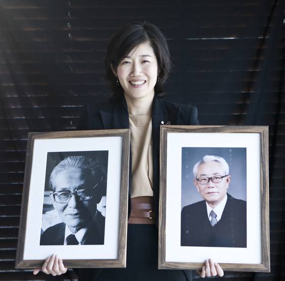 현암사 조미현 대표가 창업주인 할아버지 현암 조상원(1913~2000), 아버지 조근태(1942~2010) 2대 대표의 사진을 들고 있는 모습. 10년 전 현암사 70주년 무렵에 촬영한 사진이다. [중앙포토]