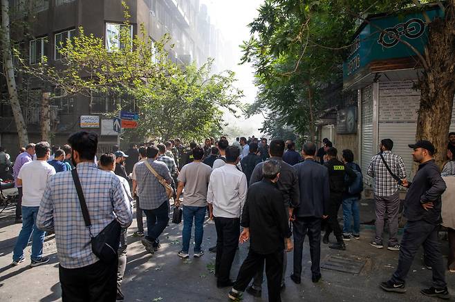 이란 수도 테헤란에서 15일(현지시간) 시민들이 이스라엘의 공습 후 연기가 피어오르는 쪽을 바라보고 있다. 로이터연합뉴스