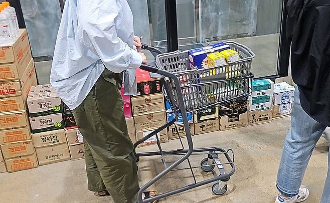 A customer pushes a cart filled with pharmaceutical goods at a drugstore in Seongnam, Gyeonggi on June 15. [JOONGANG ILBO]