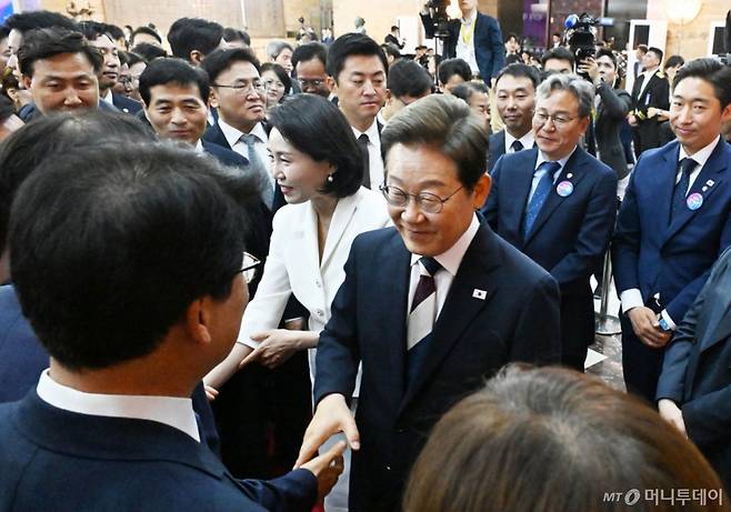 [서울=뉴시스] 국회사진기자단 = 이재명 대통령과 부인 김혜경 여사가 4일 서울 여의도 국회 로텐더홀에서 열린 제21대 대통령 취임선서를 마친 뒤 더불어민주당 의원들과 인사하고 있다. 2025.06.04. photo@newsis.com /사진=류현주