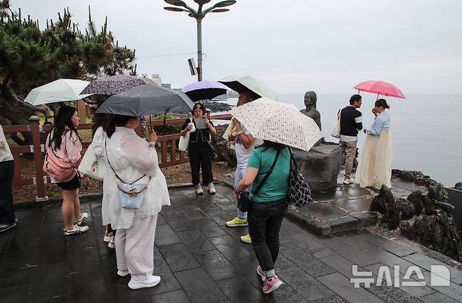 [제주=뉴시스] 우장호 기자 = 올해 첫 장맛비가 내리는 12일 오후 제주 도내 대표적인 관광지 용두암을 찾은 내·외국인 방문객이 우산을 쓴 채 관광 일정을 소화하고 있다. 2025.06.12. woo1223@newsis.com
