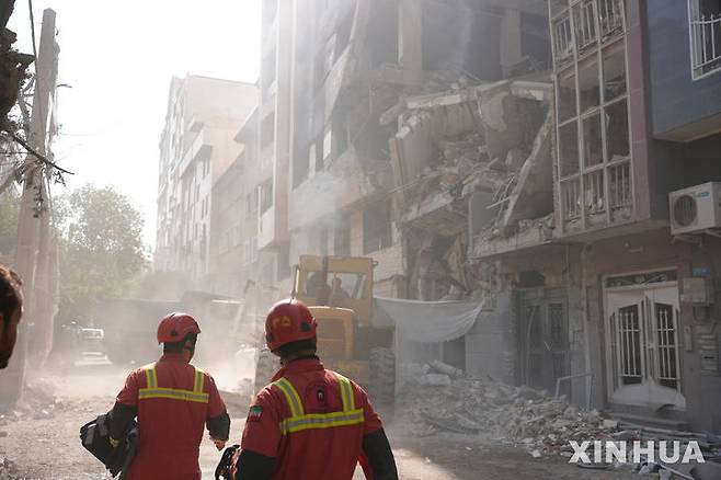 [테헤란=신화/뉴시스]지난 13일(현지 시간) 이스라엘 공습으로 파괴된 이란 테헤란의 한 건물에서 구조작업이 이뤄지고 있다. 2025.06.16.