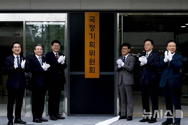 [서울=뉴시스] 김진아 기자 = 이한주(왼쪽 세번째) 국정기획위원회 위원장이 16일 서울 종로구 정부서울청사 창성동 별관에서 열린 국정기획위원회 출범 현판 제막식에서 참석자들과 제막 후 기념촬영을 하고 있다. 왼쪽 두번째부터 국정기획위원회 김용범 부위원장, 이 위원장, 진성준 부위원장, 방기선 부위원장. (공동취재) 2025.06.16. photo@newsis.com