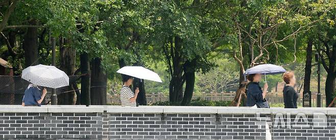 [전주=뉴시스] 김얼 기자 = 연이은 무더위가 이어지고 있는 16일 전북 전주시 전주덕진공원을 찾은 시민들이 양산으로 햇빛을 피하며 산책을 즐기고 있다. 2025.06.16. pmkeul@newsis.com