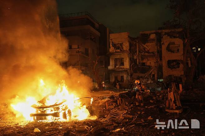 [텔아비브=AP/뉴시스] 15일(현지 시간) 이스라엘 텔아비브에서 소방관들이 이란의 미사일 공격으로 발생한 화재를 진압하고 있다. 2025.06.16.