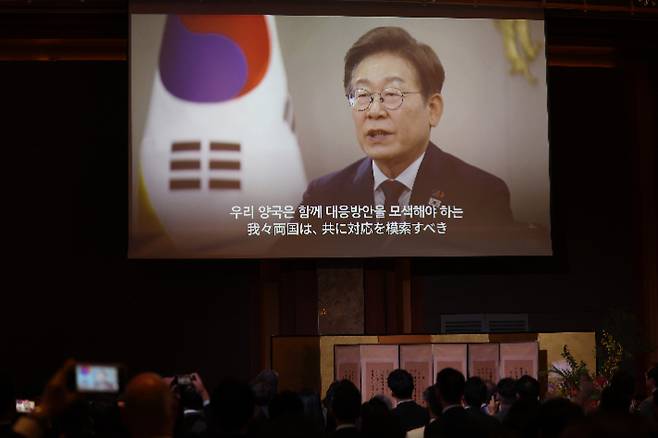 16일 서울 중구 롯데호텔에서 열린 한일 국교정상화 60주년 기념 행사에서 이재명 대통령이 보낸 영상 축사가 나오고 있다. 연합뉴스
