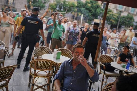 스페인 발레아레스 제도 마요르카에서 사람들이 오버투어리즘에 반대하는 시위를 벌이고 있는 가운데 관광객들이 레스토랑에 앉아 있다. 2025.6.16 AP 연합뉴스