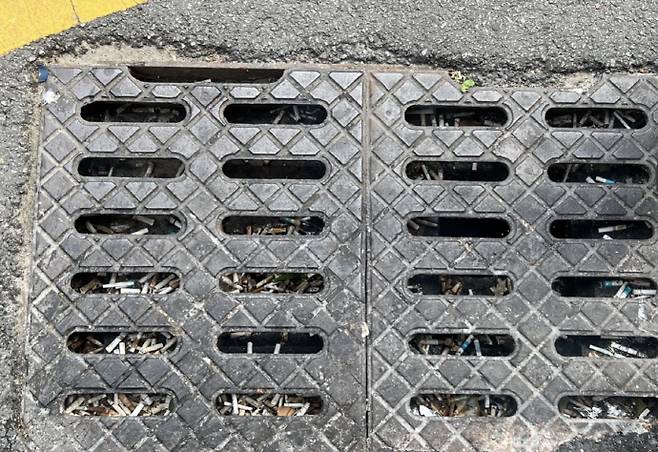 광주 동구 일대에 위치한 빗물받이가 쓰레기로 덮혀 있는 모습. /박건우 기자