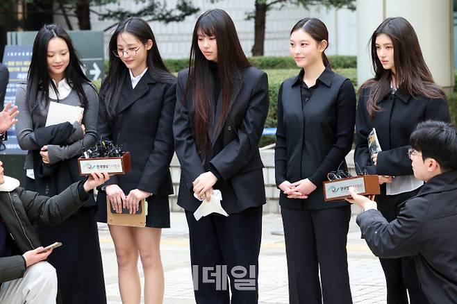 그룹 뉴진스(왼쪽부터 하니, 민지, 혜인, 해린, 다니엘)가 지난 3월 7일 서울 서초구 서울중앙지방법원에서 어도어 측이 멤버들을 상대로 제기한 ‘기획사 지위보전 및 광고계약 체결 등 금지’ 가처분 첫 심문기일을 마친 후 취재진 질문에 답하고 있다. (사진=뉴스1)