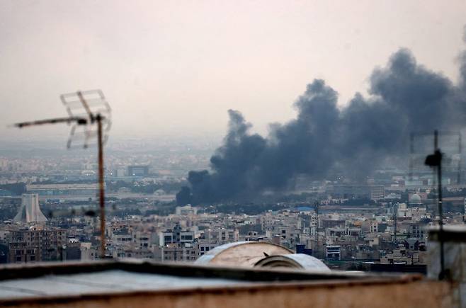 16일(현지시간) 테헤란의 아자디 타워(왼쪽) 근처에서 폭발로 인해 연기가 솟아오르고 있다. 이란 이슬람 공화국 방송(IRIB) 건물은 이날 이스라엘의 공격으로 타격을 입어 생중계가 즉시 중단됐다. (사진=AFP)