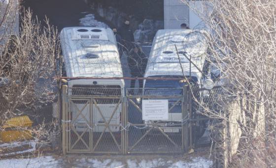 지난 1월 서울 용산구 한남동 관저에서 경호처 직원이 철조망이 쳐진 쪽문을 버스로 벽을 치고 있다. 〈사진=연합뉴스〉