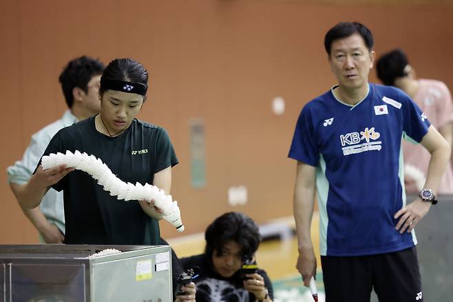 17일 충북 진천선수촌에서 열린 대한민국 배드민턴 국가대표팀 미디어데이에서 안세영이 셔틀콕을 정리하고 있다. 오른쪽은 박주봉 감독. /뉴시스
