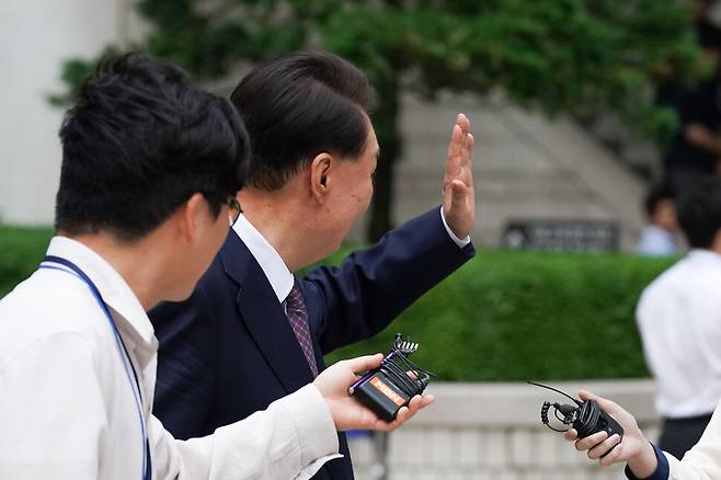 윤석열 전 대통령이 16일 서울 서초구 서울중앙지방법원에서 열린 내란 우두머리 혐의 7차 공판을 마치고 법원을 나서며 지지자들을 향해 인사하고 있다. 사진공동취재단