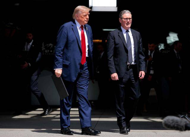 도널드 트럼프(왼쪽) 미국 대통령과 키어 스타머 영국 총리가 16일 캐나다 앨버타주 캐내내스키스에서 열린 G7 정상회의 양자회담에서 무역 협정에 서명한 후 함께 걸어가고 있다. 앨버타=AFP 연합뉴스