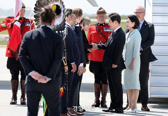 이재명 대통령과 김혜경 여사가 16일(현지시각)  캘거리국제공항에 도착해 캐나다측 관계자들과 인사하고 있다. 김창길 기자