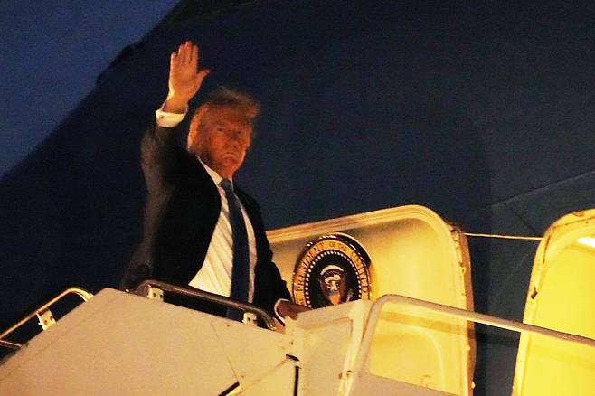 U.S. President Donald Trump waves as he boards Air Force One at Calgary International Airport in Canada on June 16, leaving the G7 summit early to head back to Washington. [AP/YONHAP]