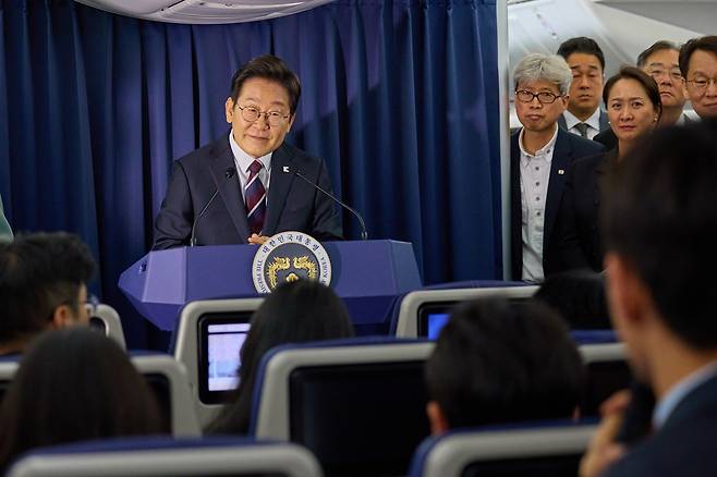 President Lee Jae Myung takes a question from a reporter aboard Air Force One en route to Calgary, Canada, to attend the G7 Summit on June 16. [JOINT PRESS CORPS]