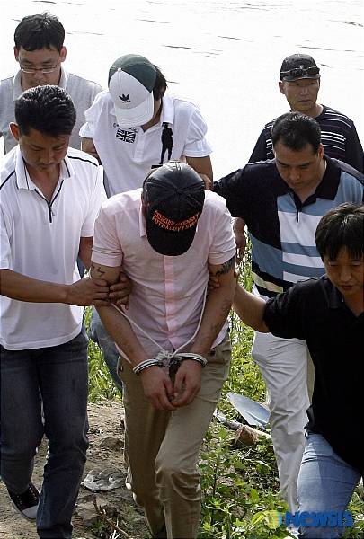 강화도 모녀 납치 살해 사건의 피의자인 하모씨와 안모씨가 2년전 다방 여종업원이었던 이복동생을 살해, 암매장한 안산시 단원구 초지동 인근 시화호 공사현장에서 현장검증을 마치고 경찰에게 이끌려 걸어나오고 있다. /사진=뉴시스