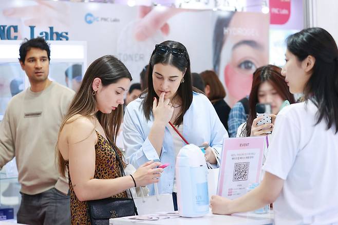 지난달 28일 서울 강남구 코엑스에서 열린 2025 서울국제화장품미용산업박람회 및 국제건강산업박람회를 찾은 외국인 관람객들이 제품을 살펴보고 있다. [연합]