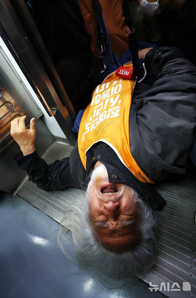 [서울=뉴시스] 박주성 기자 = 전국장애인차별철폐연대(전장연)의 출근길 지하철 탑승 시위가 1년여 만에 재개된 지난 4월21일 서울 지하철 4호선 혜화역에서 전장연 회원이 지하철 탑승을시도하다 서울교통공사 관계자와 충돌하고 있다. 2025.04.21. park7691@newsis.com
