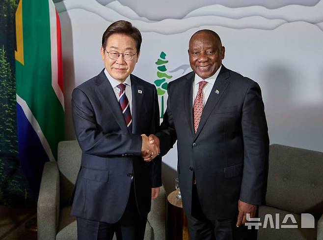 [캘거리=뉴시스] 최진석 기자 = 주요 7개국(G7) 정상회의 참석차 캐나다를 방문한 이재명 대통령이 16일(현지 시간) 캘거리 한 호텔에서 열린 시릴 라마포사 남아공 대통령과 한-남아공 정상회담에서 악수하고 있다. (공동취재) 2025.06.17. myjs@newsis.com