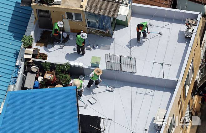 [부산=뉴시스] 하경민 기자 = 부산시자원봉사센터와 7개 기업·기관, 대학생 자원봉사자 등 130여 명이 17일 부산 남구 문현2동 일대 주택 20여 곳의 옥상에서 쿨루프(Cool Roof) 열차단 페인트를 도포하는 봉사활동을 하고 있다.쿨루프는 태양열 반사 및 열 차단 효과가 있는 친환경 도료를 주택 지붕 및 옥상에 도포해 실내온도를 효과적으로 낮추는 기술이다. 2025.06.17. yulnetphoto@newsis.com