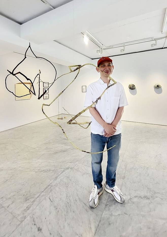 [사진=박현주미술전문기자] 구현모 작가가 나무 같은 브론즈 모빌 앞에서 포즈를 취했다. 2025.06.17. hyun@newsis.com *재판매 및 DB 금지
