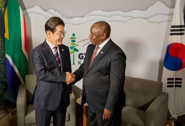 제51차 주요 7개국(G7) 정상회의에 참석한 이재명 대통령이 16일(현지시간) 캐나다 앨버타주 캘거리의 한 호텔에서 시릴 라마포사 남아프리카공화국 대통령을 만나 한·남아공 정상회담을 하며 악수하고 있다. 연합뉴스