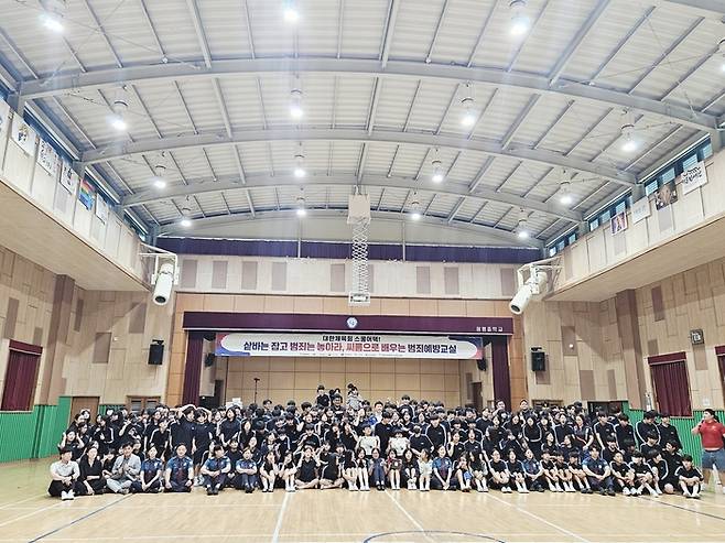 '샅바는 잡고 범죄는 놓아라 - 씨름으로 배우는 범죄예방교실'에 참가한 광평중 학생들과 구미시청 씨름단, 대한체육회, 씨름진흥원, 구미경찰서 관계자들이 단체 사진 촬영을 하고 있다. <씨름진흥원 제공>