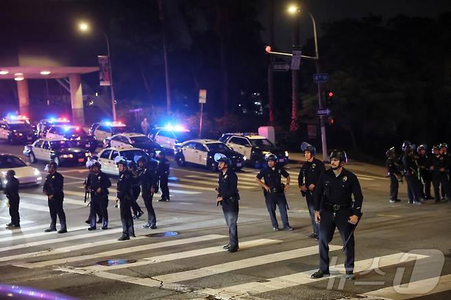 미국 캘리포니아주 로스앤젤레스(LA) 시내에서 이민 단속 작전에 반대하는 시위로 인해 야간 통행금지령이 선포되자 법 집행관들이 경비를 서고 있다. 2025.6.10 ⓒ 로이터=뉴스1 ⓒ News1 김경민 기자
