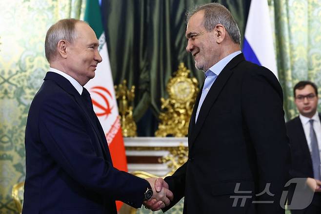 블라디미르 푸틴 러시아 대통령이 17일 (현지시간) 모스크바 크렘린궁에서 마수드 페제시키안 이란 대통령과 만나 악수를 하고 있다. 2025.01.18 ⓒ AFP=뉴스1 ⓒ News1 우동명 기자