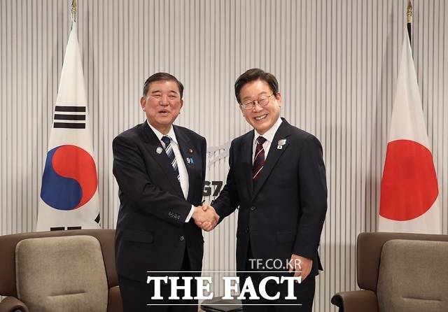 [이재명 대통령이 17일(현지 시간) 캐나다 앨버타주 캐내내스키스 주요 7개국(G7) 정상회의장에서 열린 한일 정상회담에서 이시바 시게루 일본 총리와 악수하며 기념촬영을 하고 있다. /뉴시스