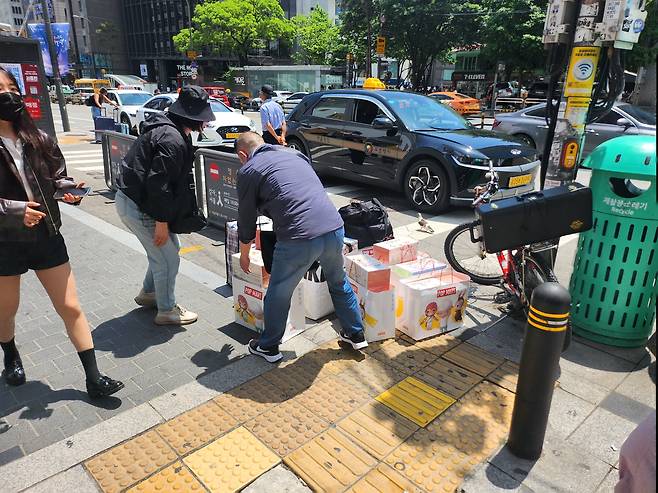 22일 낮 12시쯤 서울 중구 명동 길거리에서 중국인 리셀러 일행이 팝마트에서 구매한 제품들을 모으고 있다. /김관래 기자