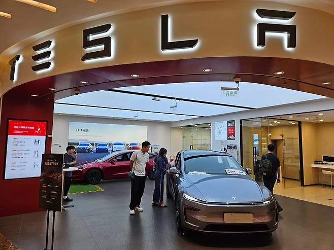 6월 중국 베이징 싼리툰의 테슬라 자동차 매장에서 방문객이 차량을 둘러보고 있다. /베이징=이은영 특파원