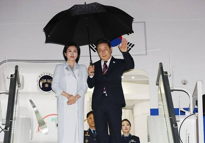 이재명 대통령과 김혜경 여사가 17일(현지시간) 51차 주요 7개국(G7) 정상회의 일정을 마치고 캐나다 캘거리국제공항에서 귀국하며 공군 1호기 올라 인사하고 있다. ⓒ연합뉴스