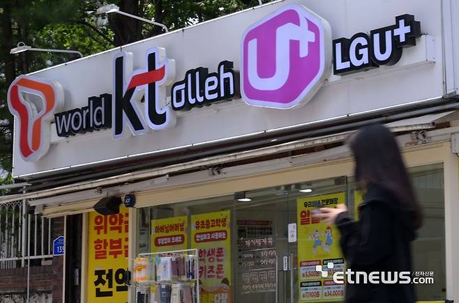 SK텔레콤 유심칩 해킹 사태가 촉발한 통신사 보조금 경쟁이 치열해지고 있다. 주말 서울 시내 한 이동통신사 대리점 앞을 지나는 시민들.