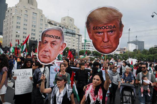 팔레스타인 지지 시위 참가자들이 15일 멕시코 멕시코시티에서 이마에 ‘대량 학살’이라고 쓴 도널드 트럼프 미국 대통령과 베냐민 네타냐후 이스라엘 총리 얼굴 형상의 손 팻말을 들고 있다. 멕시코시티=로이터 연합뉴스