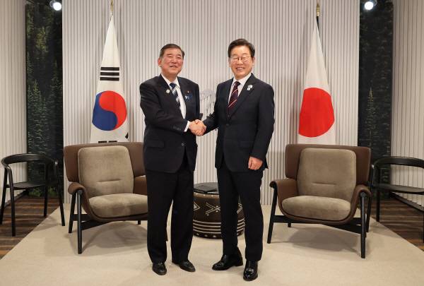 이재명 대통령이 17일(현지시간) 캐나다 앨버타주 캐내내스키스 주요 7개국(G7) 정상회의장에서 열린 한일 정상회담에서 이시바 시게루 일본 총리와 악수하며 기념촬영을 하고 있다. 연합뉴스