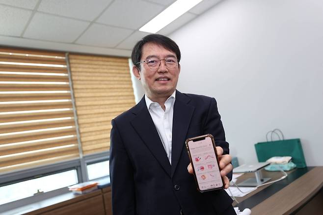 송민호 실크롱제비티 창업자(KAIST 의과학대학원 교수)가 실크롱제비티 애플리케이션(앱)을 들어보이고 있다. [사진=KAIST]