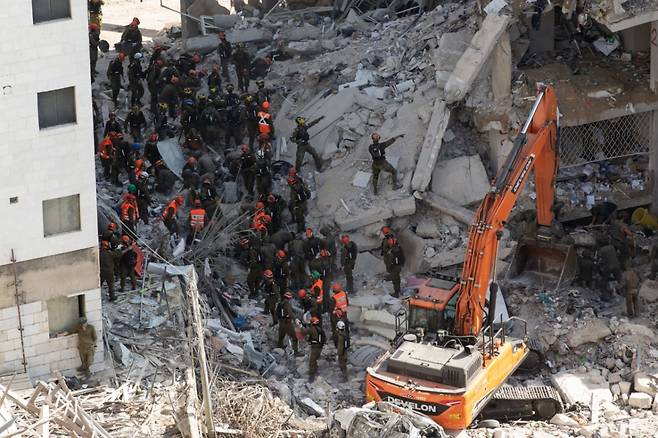 [바트얌=신화/뉴시스] 15일(현지 시간) 이스라엘 중부 바트얌에서 구조대와 보안군 요원들이 이란의 미사일 공격으로 파괴된 건물 잔해를 수색하고 있다. 이스라엘 국영 칸TV에 따르면 지난 13일부터 이어진 이란의 보복 공격으로 인한 사망자는 14명에 달한다. 2025.06.16. /사진=민경찬
